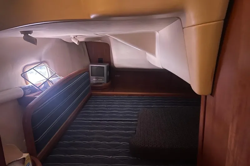 Slide: The Image of Cozy cabin interior of 2006 Hunter 36 sailboat with striped seating and small TV. - 9