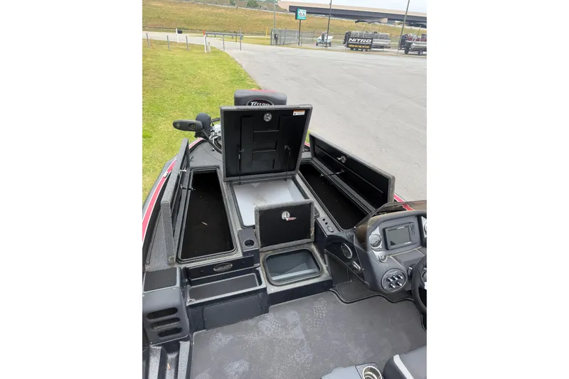 Slide: The Image of 2022 Triton 18 TrX boat interior with open storage compartments and control panel. - 4