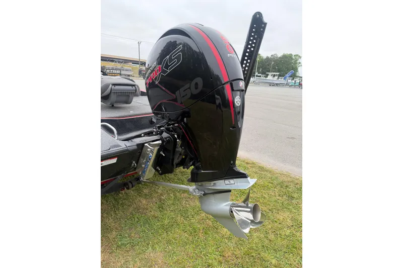 Slide: The Image of 2022 Triton 18 TrX boat with a powerful outboard motor, parked on grass. - 9