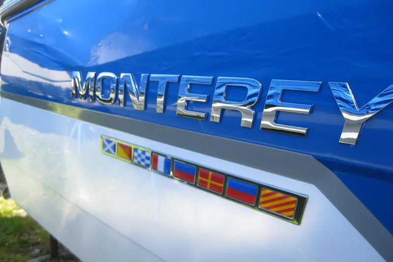 Slide: The Image of 2018 Monterey 278SS Super Sport boat with nautical flags on blue and white hull. - 4