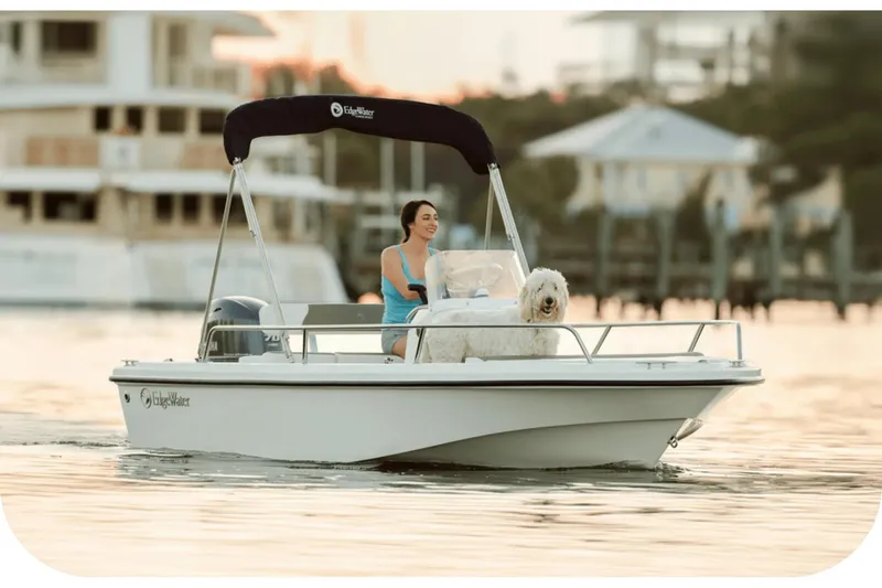 Slide: The Image of Woman and dog on Edgewater 158CS boat, 2026 model, at sunset. - 6