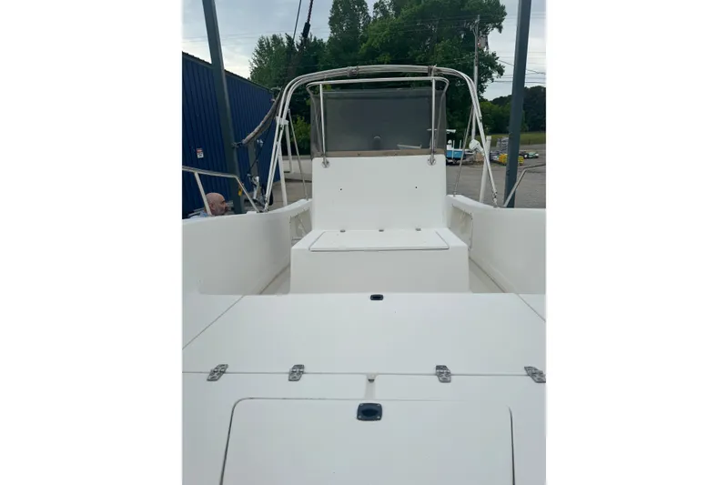 Slide: The Image of 1997 Henry O 199 boat interior with white seating and console, docked outdoors. - 10