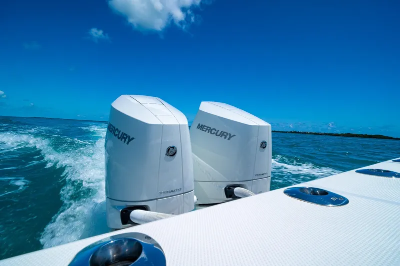 Slide: The Image of Twin Mercury outboard engines on a 2025 SeaVee 322Z boat cruising in clear blue waters. - 10