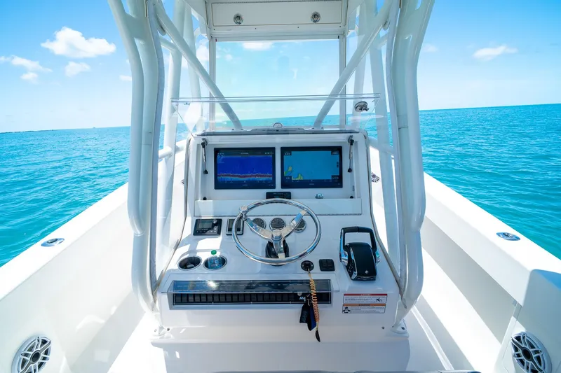 Slide: The Image of 2025 SeaVee 322Z boat helm with dual screens on open ocean. - 21