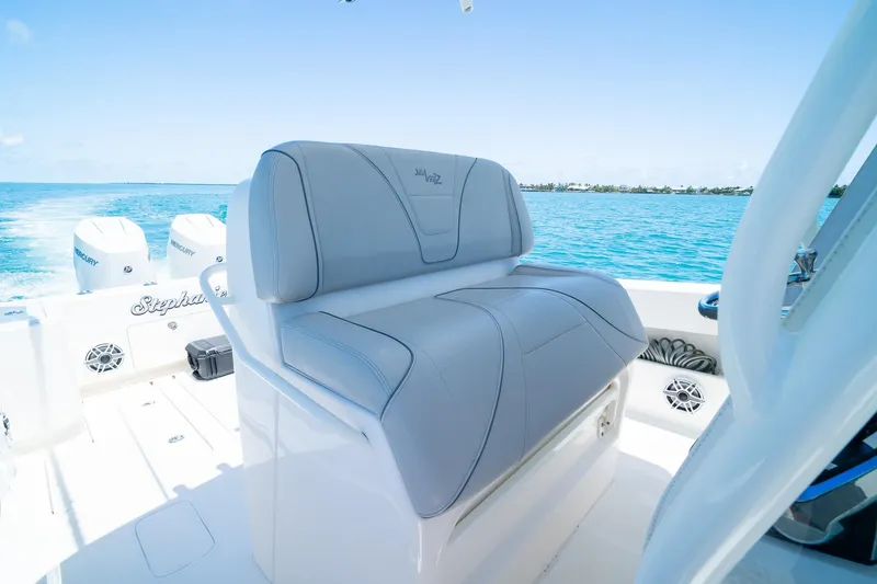 Slide: The Image of 2025 SeaVee 322Z boat with cushioned seating, ocean backdrop, and twin Mercury engines. - 25