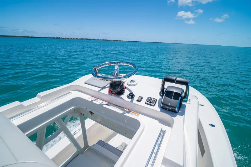Slide: The Image of 2025 SeaVee 322Z boat helm with ocean view, featuring steering wheel and controls. - 34