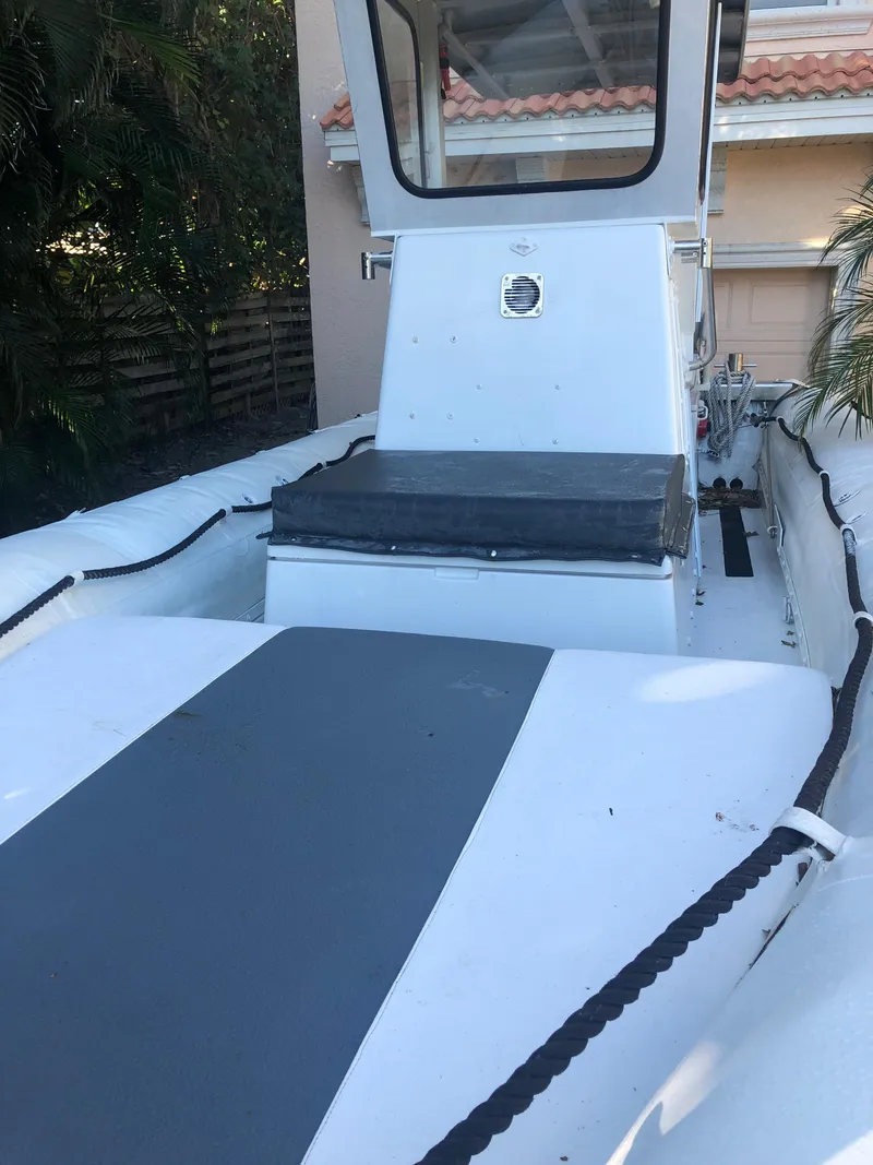 Slide: The Image of 2001 Willard 25 boat with white and gray deck, docked near a house. - 17