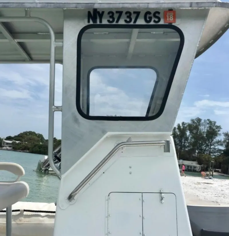 Slide: The Image of Side view of a 2001 Willard 25 boat docked near a beach. - 3