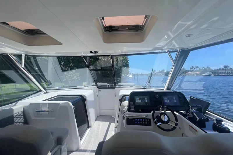 Slide: The Image of Interior view of 2025 Aquila 36 Sport yacht with modern dashboard and scenic waterway. - 21
