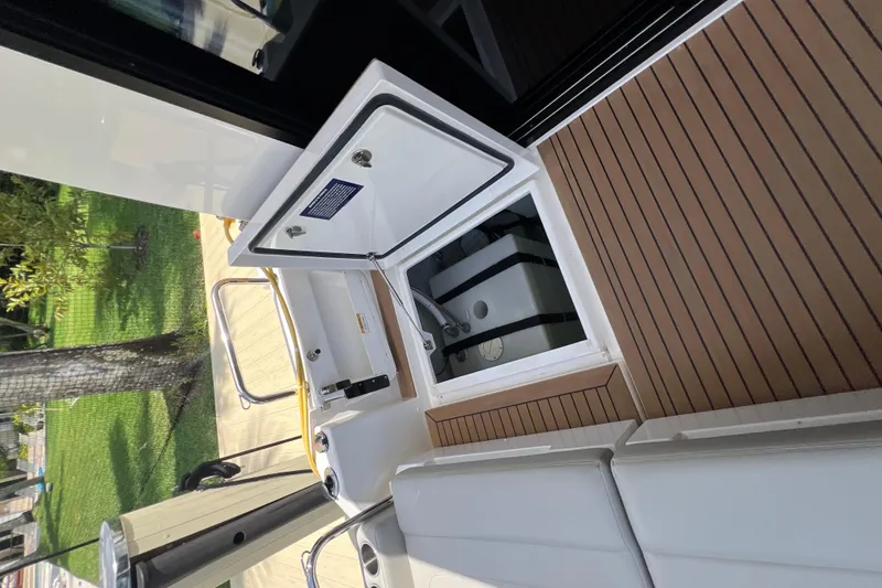 Slide: The Image of 2025 Aquila 36 Sport boat interior with open storage compartment and cushioned seating. - 35