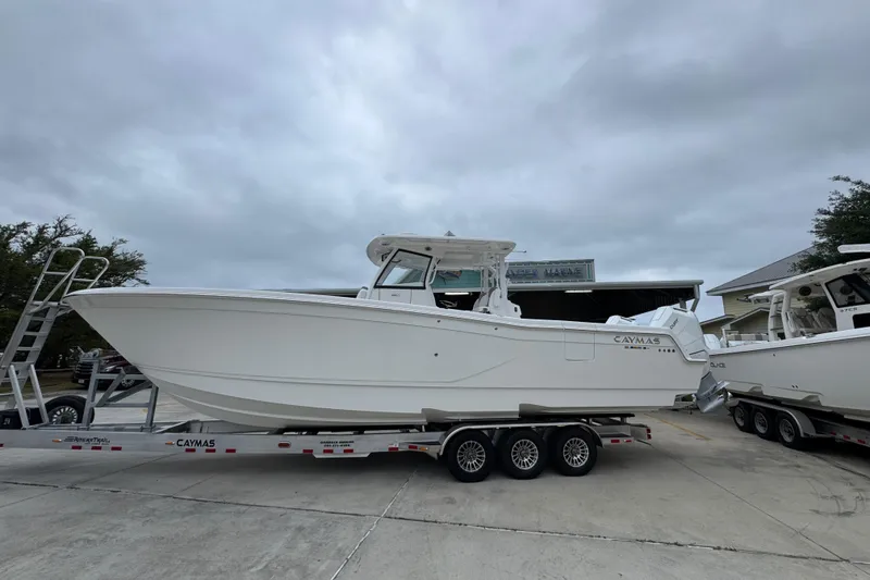 The Image of 2026 Caymas 34 CT boat on trailer, parked outdoors under cloudy sky. - 1
