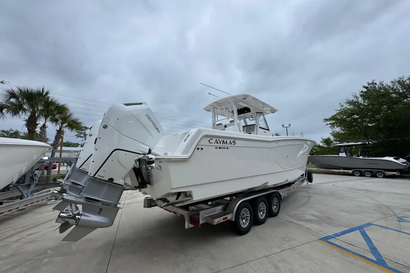 Slide: The Image of 2026 Caymas 34 CT boat on trailer, parked outdoors under cloudy sky. - 12