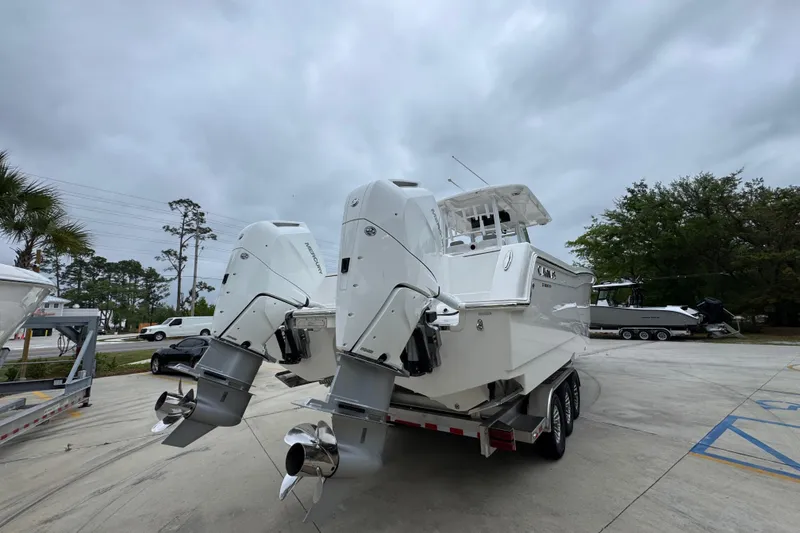 Slide: The Image of 2026 Caymas 34 CT boat with dual outboard motors on a trailer, overcast sky. - 13