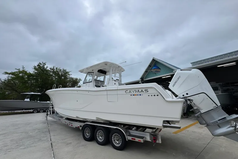 Slide: The Image of 2026 Caymas 34 CT boat on trailer with Mercury engines, parked outdoors. - 16