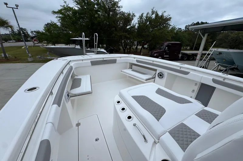 Slide: The Image of 2026 Caymas 34 CT boat interior with white and gray seating, docked outdoors. - 22