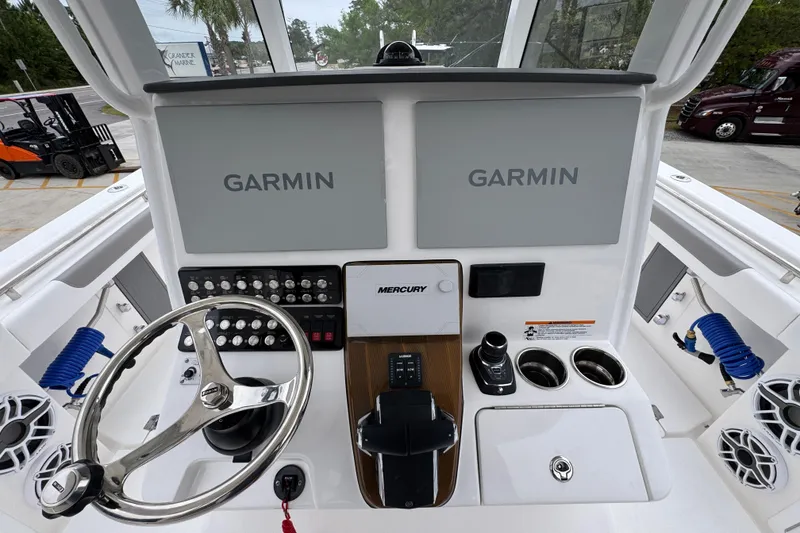 Slide: The Image of Helm of 2026 Caymas 34 CT boat with Garmin displays and Mercury controls. - 31