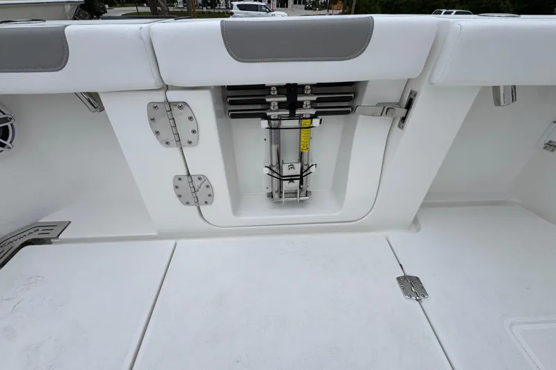 Slide: The Image of 2026 Caymas 34 CT boat interior, featuring a white and gray seating area with storage compartment. - 37