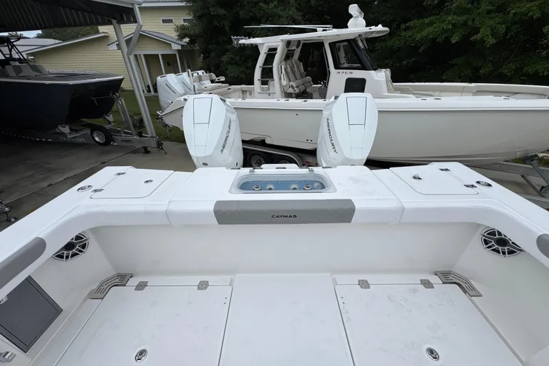 Slide: The Image of 2026 Caymas 34 CT boat with dual Mercury engines, docked near a house. - 39
