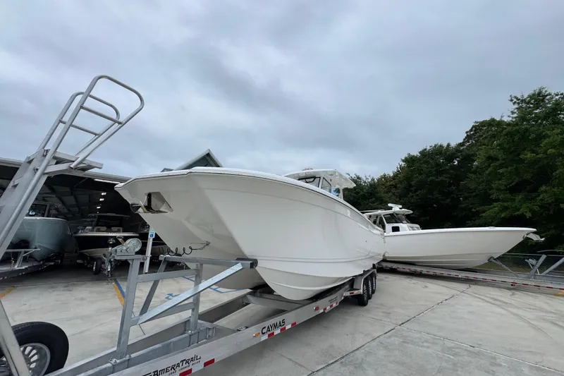 Slide: The Image of 2026 Caymas 34 CT boat on trailer, parked outdoors under cloudy sky. - 4