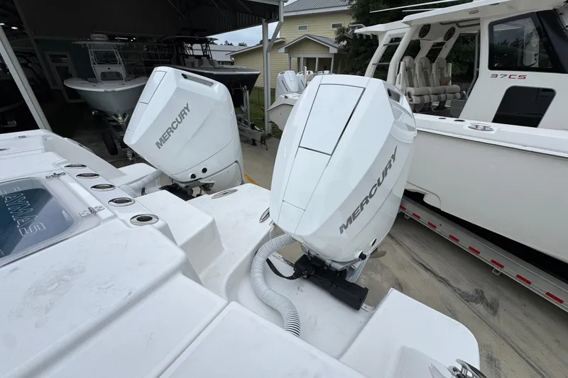 Slide: The Image of 2026 Caymas 34 CT boat with dual Mercury outboard engines, docked alongside another vessel. - 41