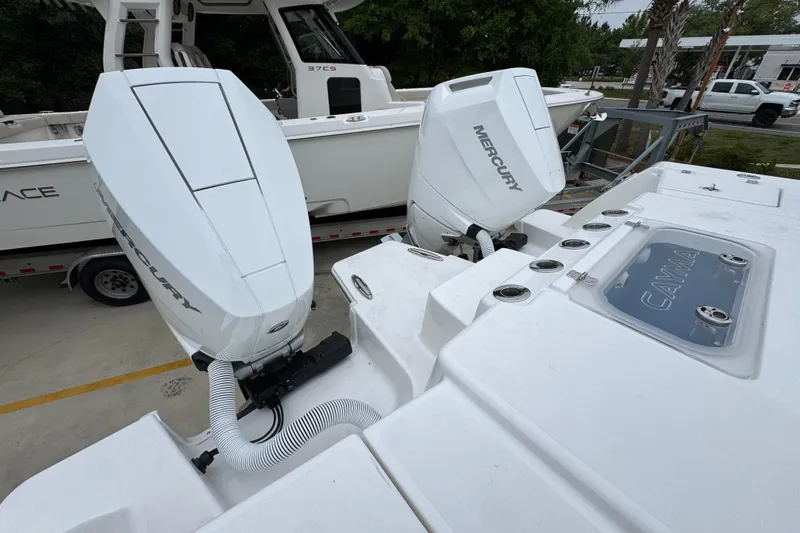 Slide: The Image of 2026 Caymas 34 CT boat with dual Mercury outboard engines, docked near another vessel. - 42