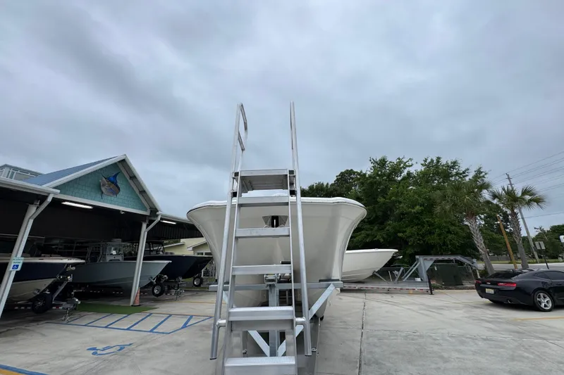 Slide: The Image of 2026 Caymas 34 CT boat on display at a dealership with overcast skies. - 5