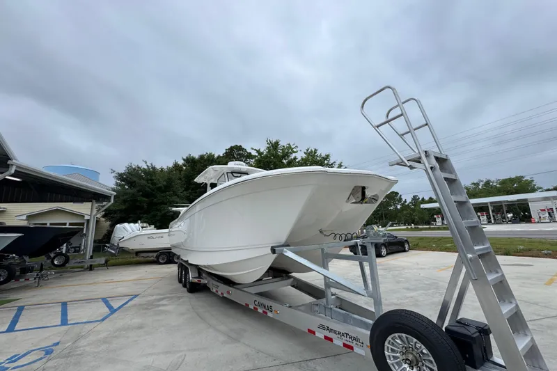 Slide: The Image of 2026 Caymas 34 CT boat on trailer, parked outdoors under cloudy sky. - 6