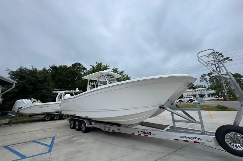 Slide: The Image of 2026 Caymas 34 CT boat on trailer, parked outdoors under cloudy sky. - 7