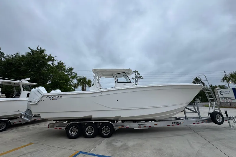 Slide: The Image of 2026 Caymas 34 CT boat on trailer, parked outdoors under cloudy sky. - 9
