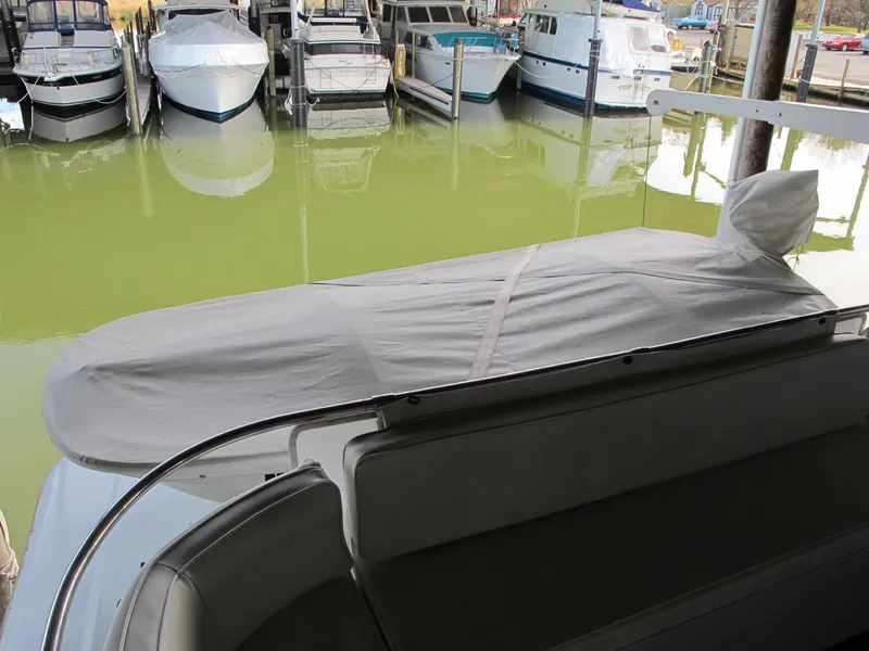 Slide: The Image of 1971 Chris-Craft 57 Constellation docked, covered, with other boats. - 25