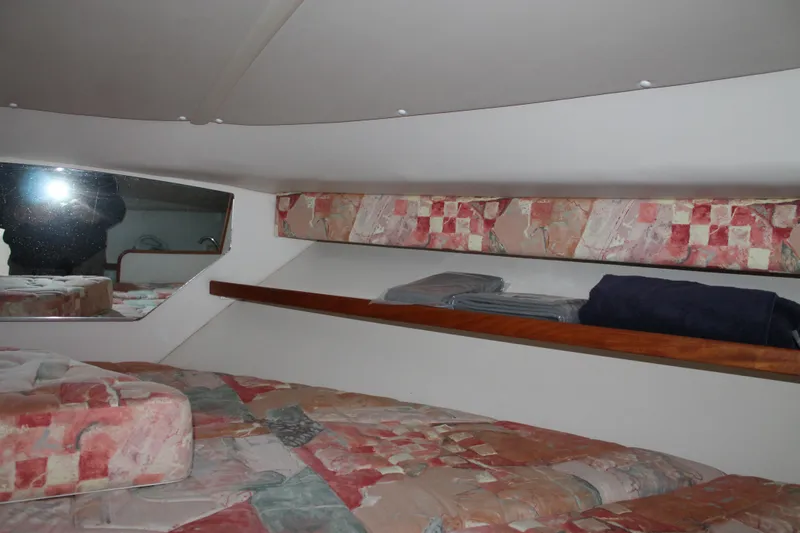 Slide: The Image of 1998 Tiara Yachts 2900 Coronet cabin interior with patterned bedding and storage shelf. - 21