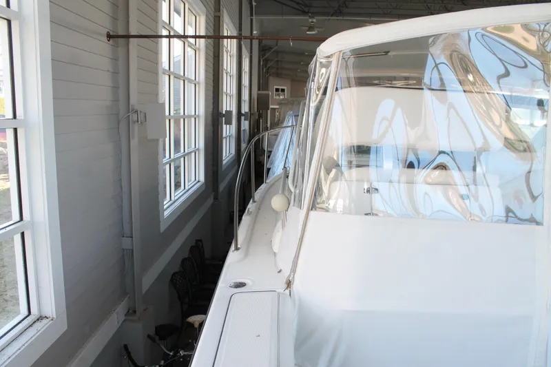 Slide: The Image of 1998 Tiara Yachts 2900 Coronet docked indoors, showcasing sleek design and clear windows. - 9