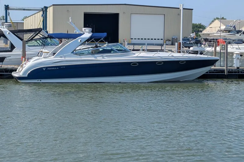 The Image of 2004 Formula 400 Super Sport boat docked at marina, blue and white design. - 0