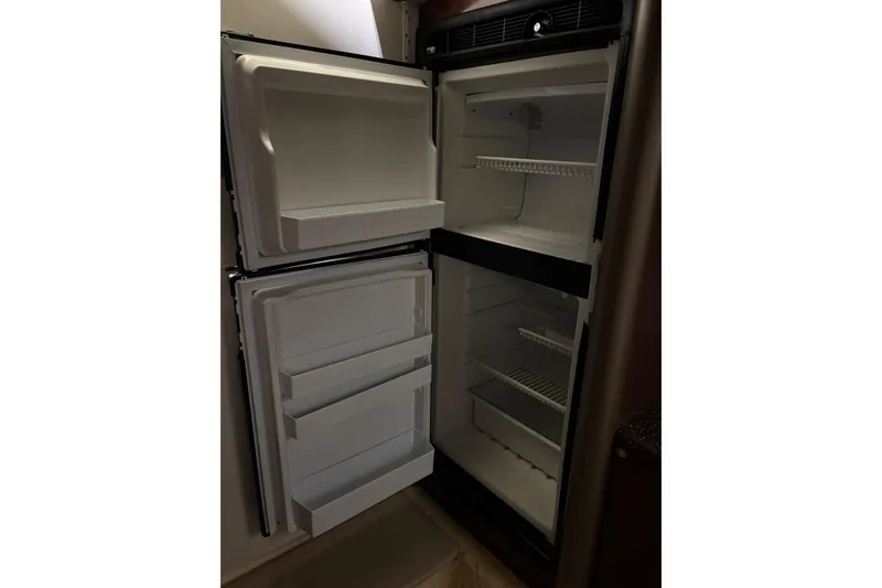 Slide: The Image of Open refrigerator in a 2004 Formula 400 Super Sport boat, showing empty shelves. - 32