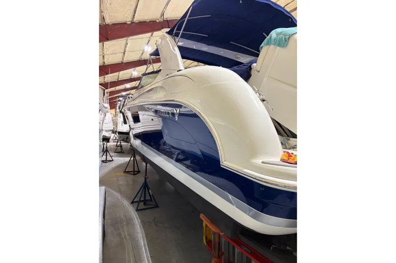 Slide: The Image of 2004 Formula 400 Super Sport boat in storage, featuring sleek blue and white design. - 6