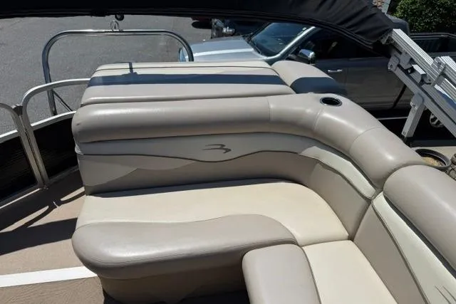 Slide: The Image of 2010 Bennington 20SLi pontoon boat with beige seating and cup holder. - 12