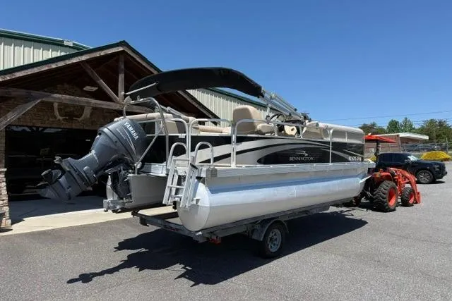 Slide: The Image of 2010 Bennington 20SLi pontoon boat on trailer, parked outdoors near a building. - 3