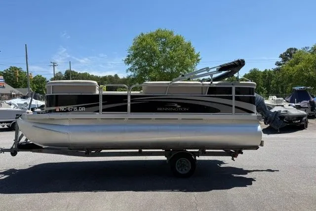 Slide: The Image of 2010 Bennington 20SLi pontoon boat on trailer, parked outdoors under clear sky. - 5