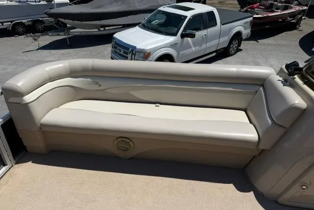 Slide: The Image of 2010 Bennington 20SLi boat interior with beige seating, parked near a white truck. - 9