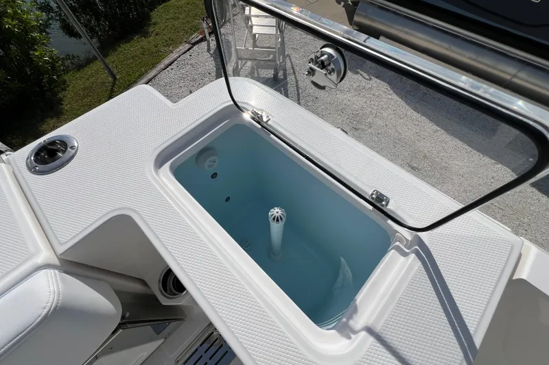 Slide: The Image of Livewell on 2026 Robalo R300 Center Console boat, open lid, white interior. - 14