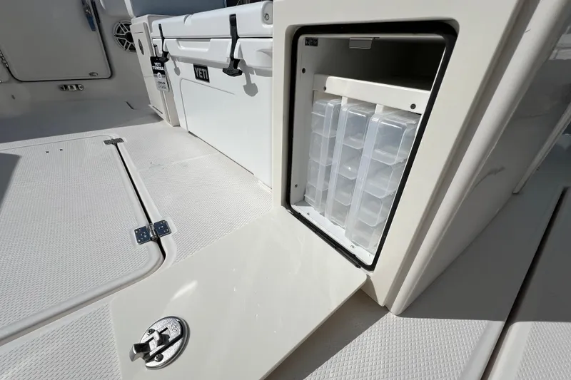 Slide: The Image of 2026 Robalo R300 Center Console boat with open storage compartment and Yeti cooler. - 18