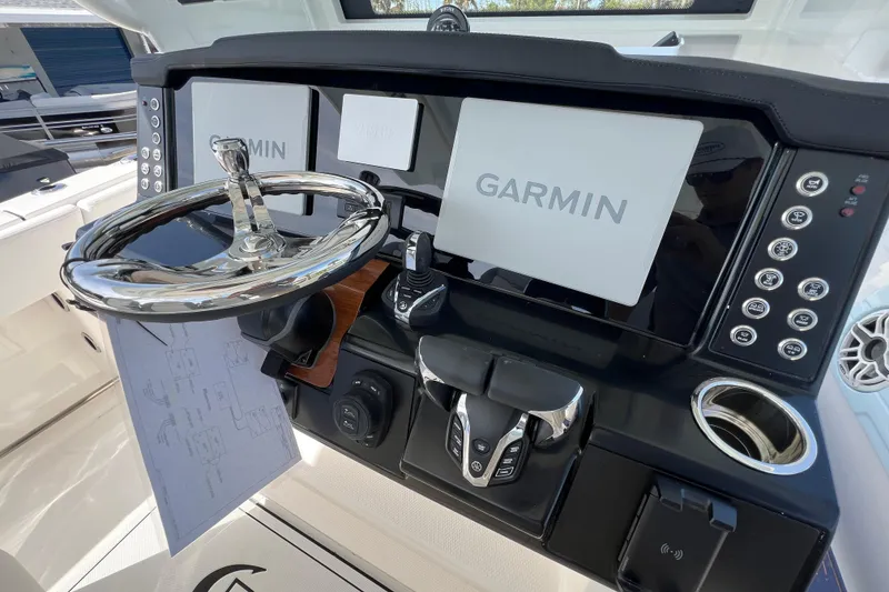 Slide: The Image of 2026 Robalo R300 Center Console dashboard with Garmin navigation system and sleek steering wheel. - 23