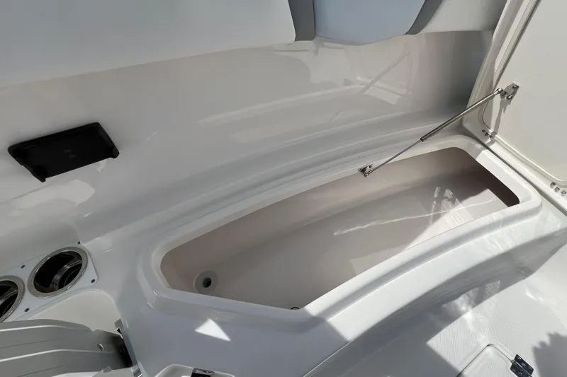Slide: The Image of 2026 Robalo R300 Center Console boat storage compartment with open lid and sleek design. - 33