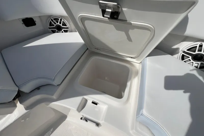 Slide: The Image of 2026 Robalo R300 Center Console boat storage compartment with cushioned seating and speaker. - 34