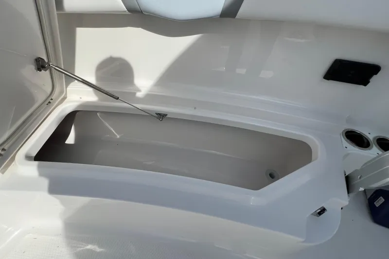 Slide: The Image of 2026 Robalo R300 Center Console storage compartment with open lid and cup holders. - 35