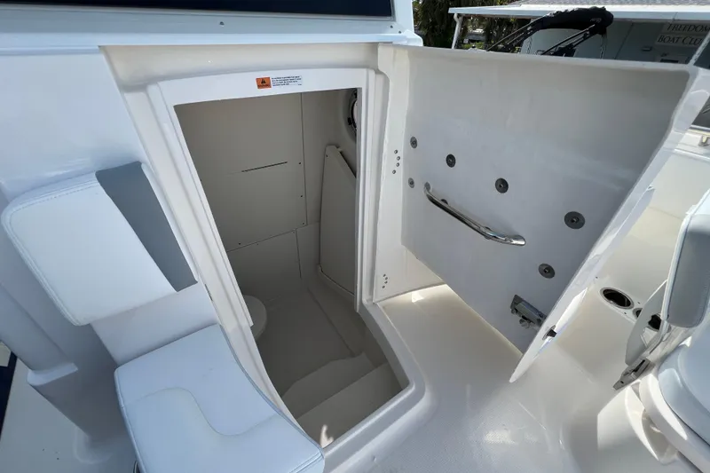Slide: The Image of 2026 Robalo R300 Center Console boat interior storage compartment with open door. - 37
