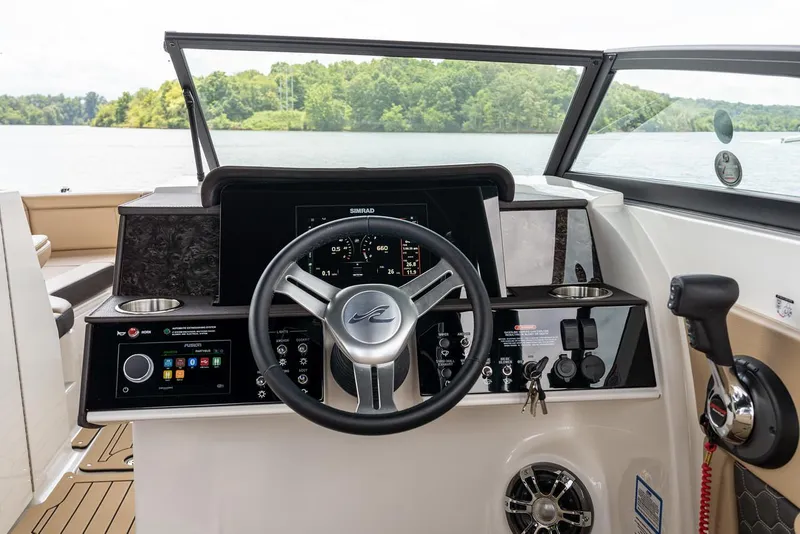 Slide: The Image of Manufacturer Provided Image: 2025 Sea Ray SDX 290 helm with modern controls and scenic lake view. - 9