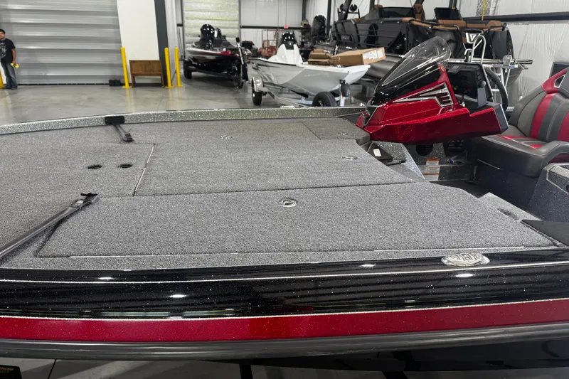 Slide: The Image of 2022 Ranger Z520R boat interior with gray deck and red accents in a showroom. - 10