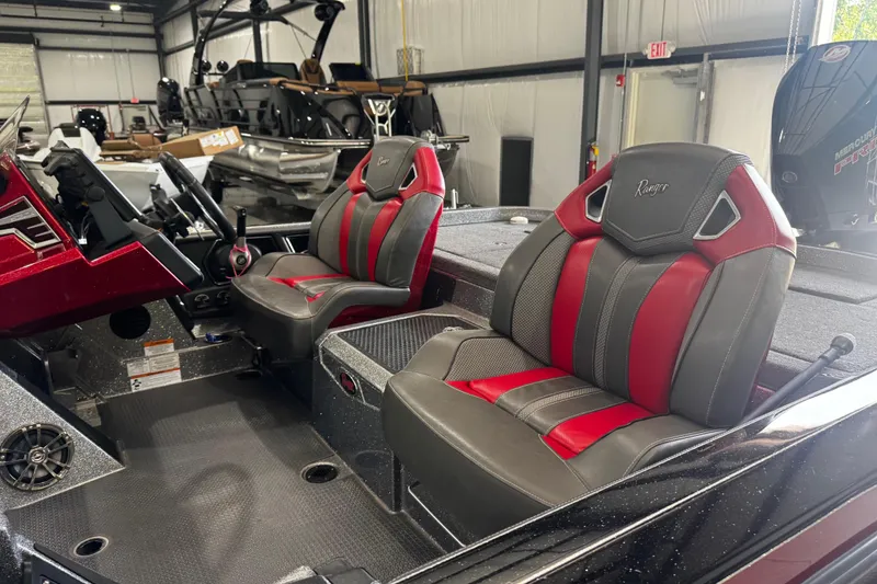 Slide: The Image of 2022 Ranger Z520R boat interior with red and gray seats in a showroom. - 12