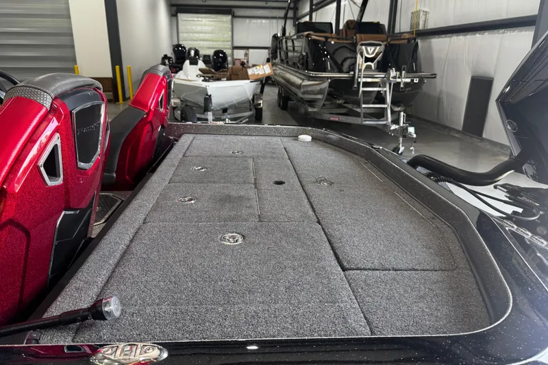 Slide: The Image of 2022 Ranger Z520R boat interior with red seats and storage compartments in a showroom. - 14